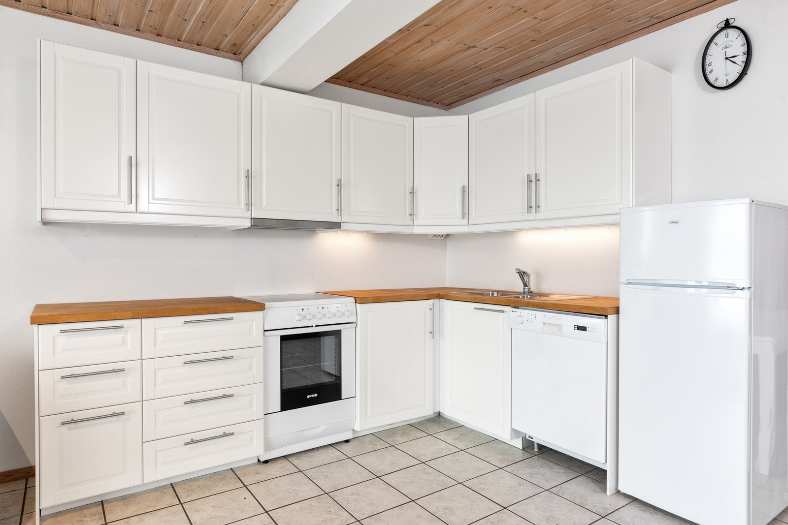 Kjøkkenet i gjesteleiligheten er fra 2015 og ligger i åpent i stuen med vinkelform. Galleribilde