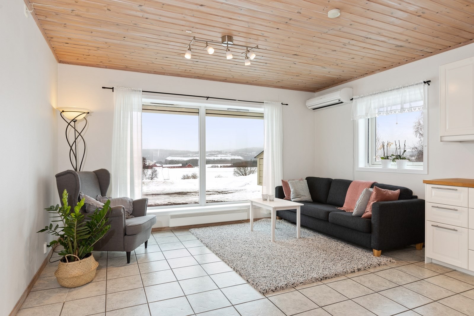 Stuen i gjesteleiligheten har lysinnslipp fra vinduer på to sider, hvor utsikten fra vinduene i fremkant er landlig. Galleribilde