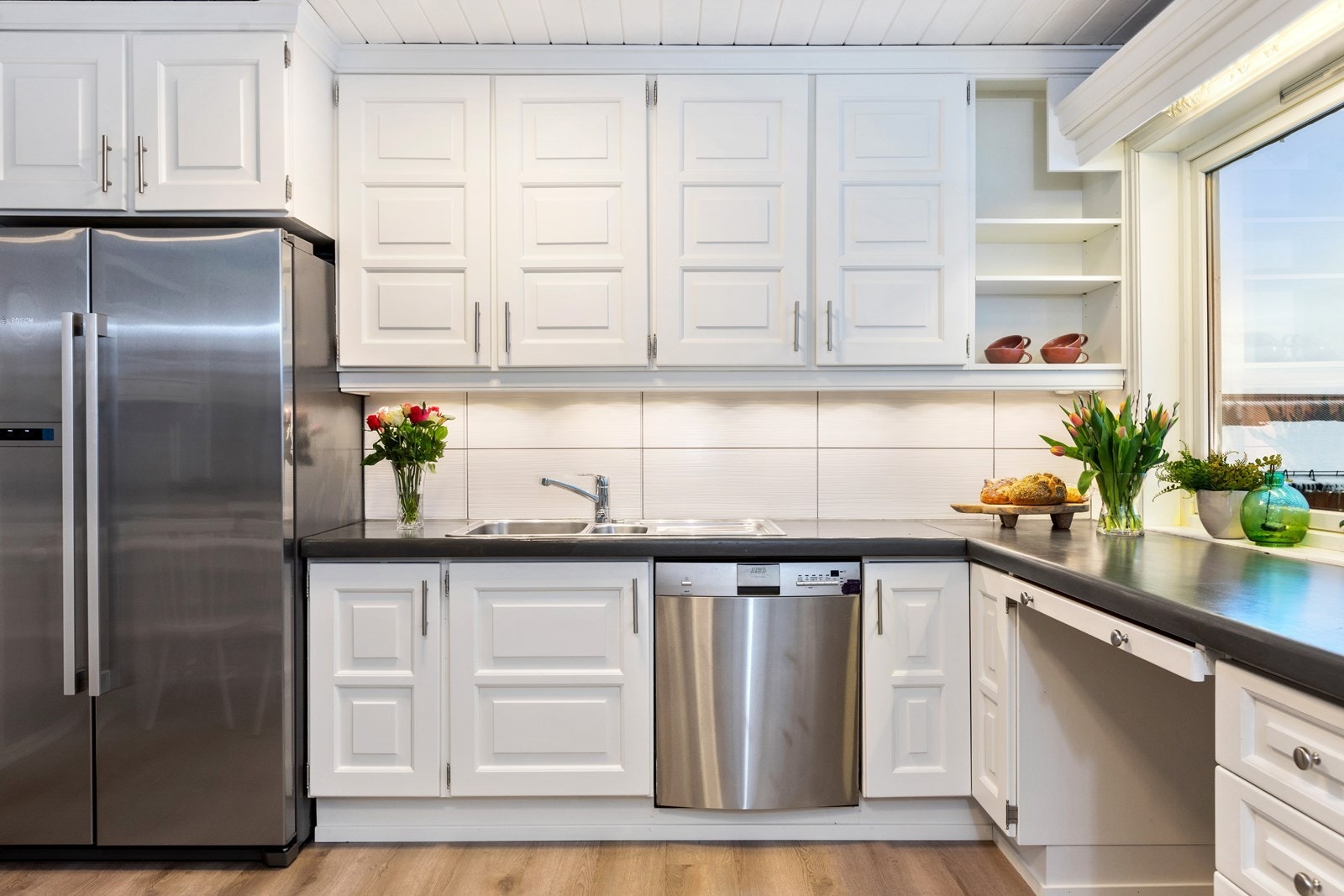 Det er dobbel vaskekum i benk og lyse fliser på veggene i bakkant. Galleribilde