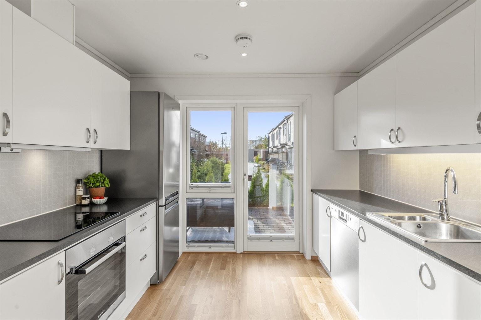 Fra kjøkkenet er det en glassdør ut mot en hyggelig markterrasse og hage. Galleribilde