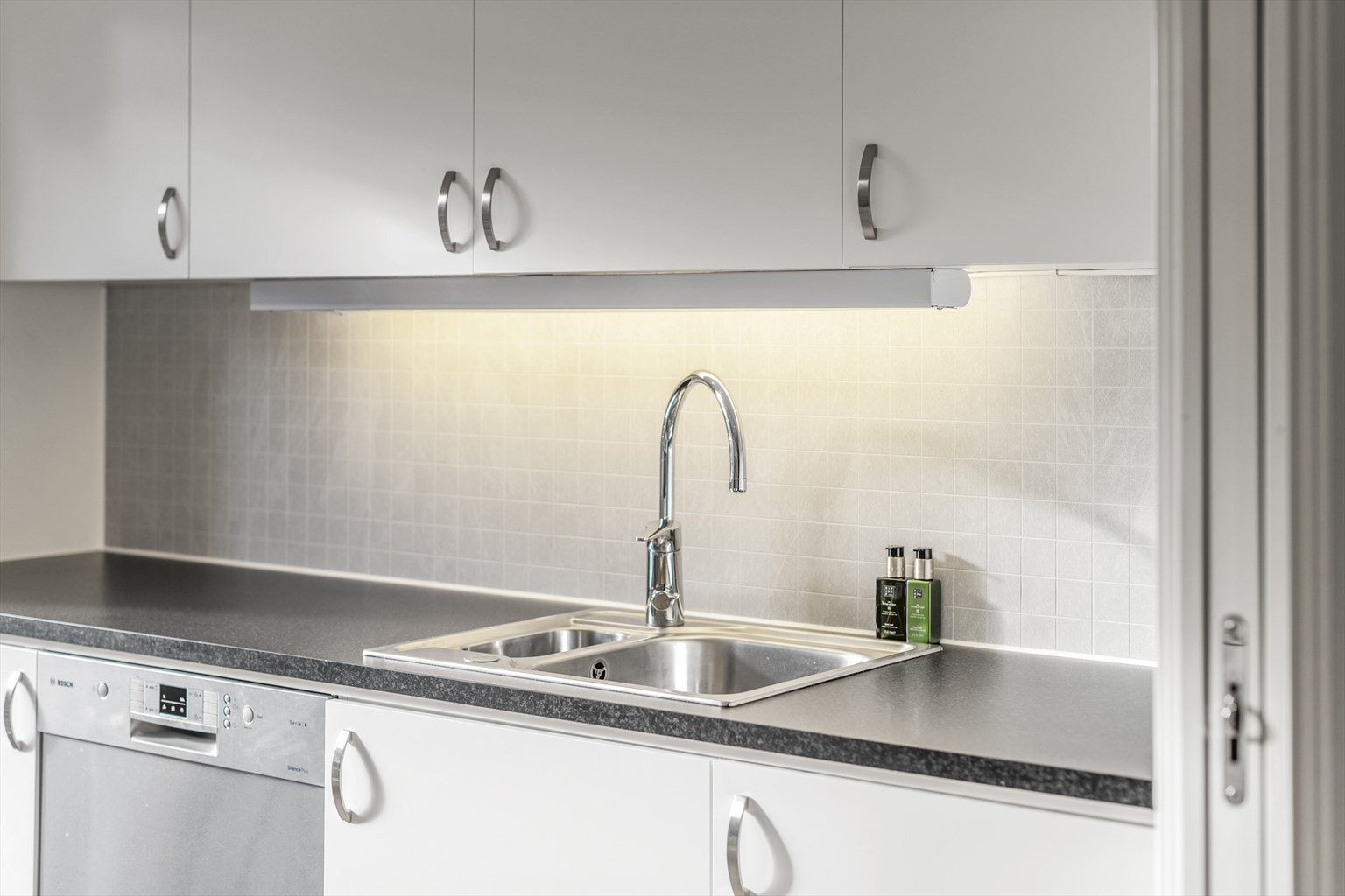 Kjøkkeninnredningen har en elegant og tidløs karakter, med lyse glatte fronter og god lagringsplass. Galleribilde