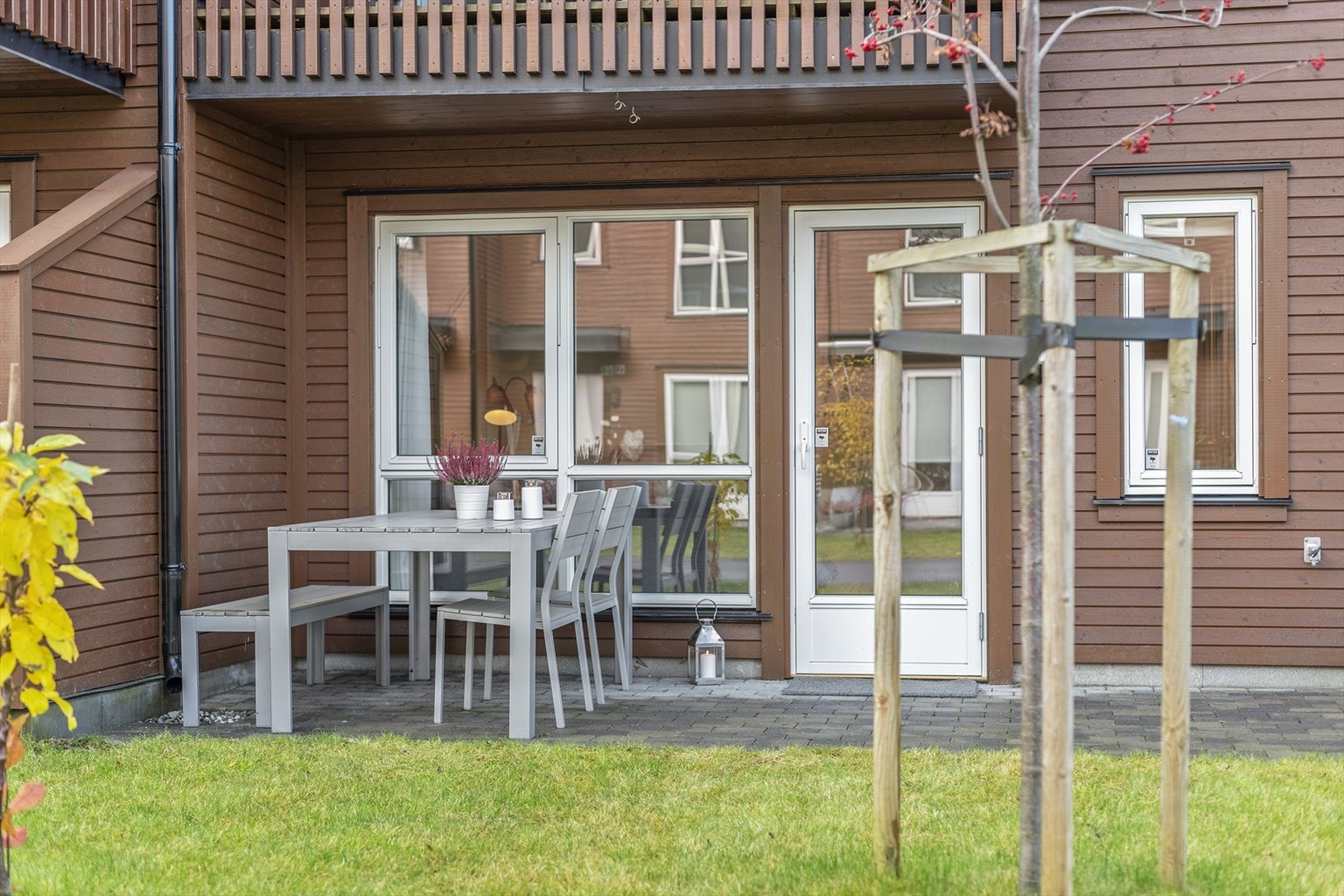 Fra underetasjen er det utgang til en hyggelig uteplass med belegningssten og gressplen. Galleribilde