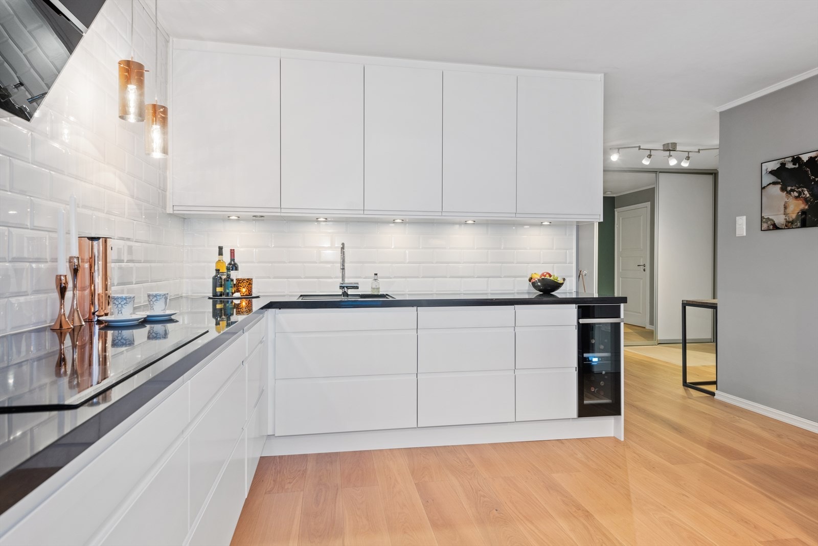 Hvite fronter og belysning under overskap. God skap- og benkeplass. Galleribilde