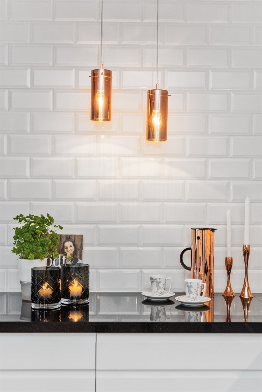 Pene hvite fliser mellom overskap/benk og helt opp til taket på langveggen. Galleribilde