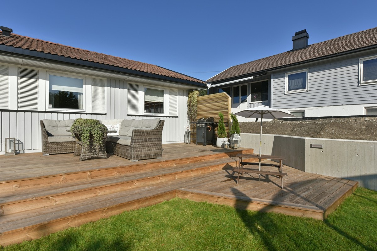 Uteplassen er bygd over to nivåer, og det er trapp ned til hagen. Galleribilde