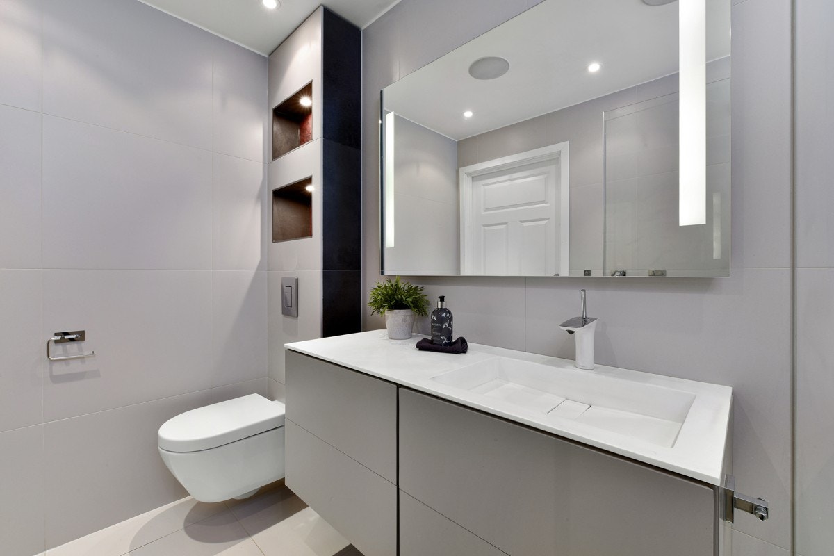 Den øvrige innredningen består av heldekkende servant i kompositt med skuffer og et speil med integrert belysning. Galleribilde