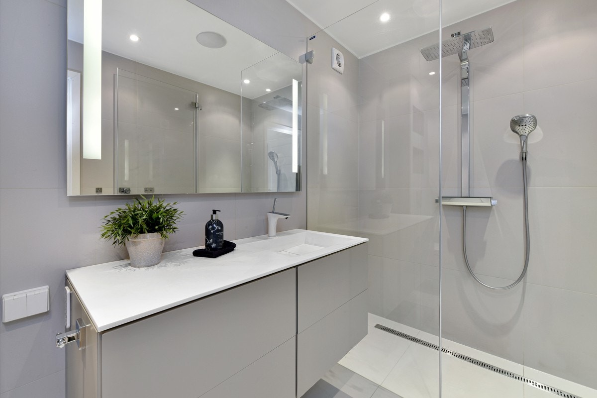 Det virkelig flotte og moderne badet har store, grå vegg- og gulvfliser. Galleribilde