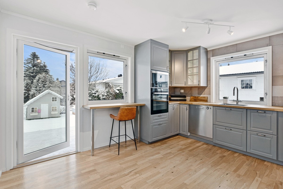 Fra kjøkkenet er det en terrassedør og ved vinduet er det en smart barløsning med rom for to sitteplasser. Galleribilde