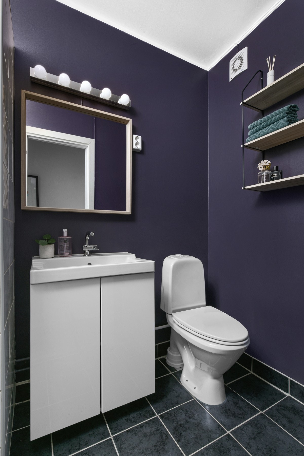 Det er lys og speil over servantinnredning, samt frittstående toalett. Galleribilde