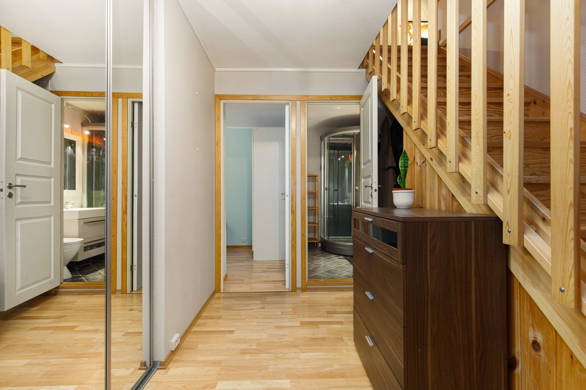 Stor skyvedørsgarderobe med speil i gang og inngang til soverom og bad