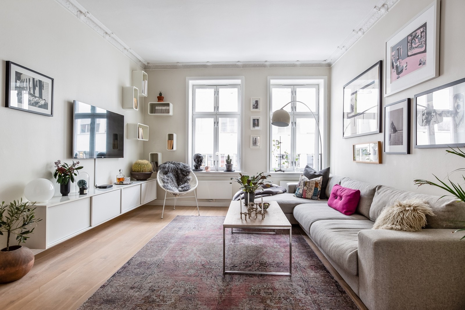 Lys og tiltalende stue med store vindusflater og generøs takhøyde. Medfølgende tv-benk og hyller. Galleribilde