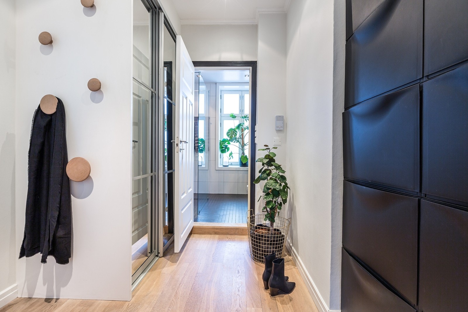 Innbydende entré med innfelt skyvedørsgarderobe og plass til skohyller. Vaskemaskin og tørketrommel er plassert i skyvedørsgarderobe. Galleribilde