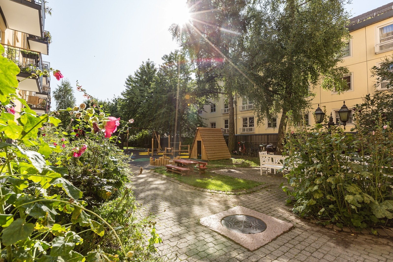 Frodig beplantning med blomster, prydbusker og trær gir trivsel og hygge på fine sommerdager. Galleribilde