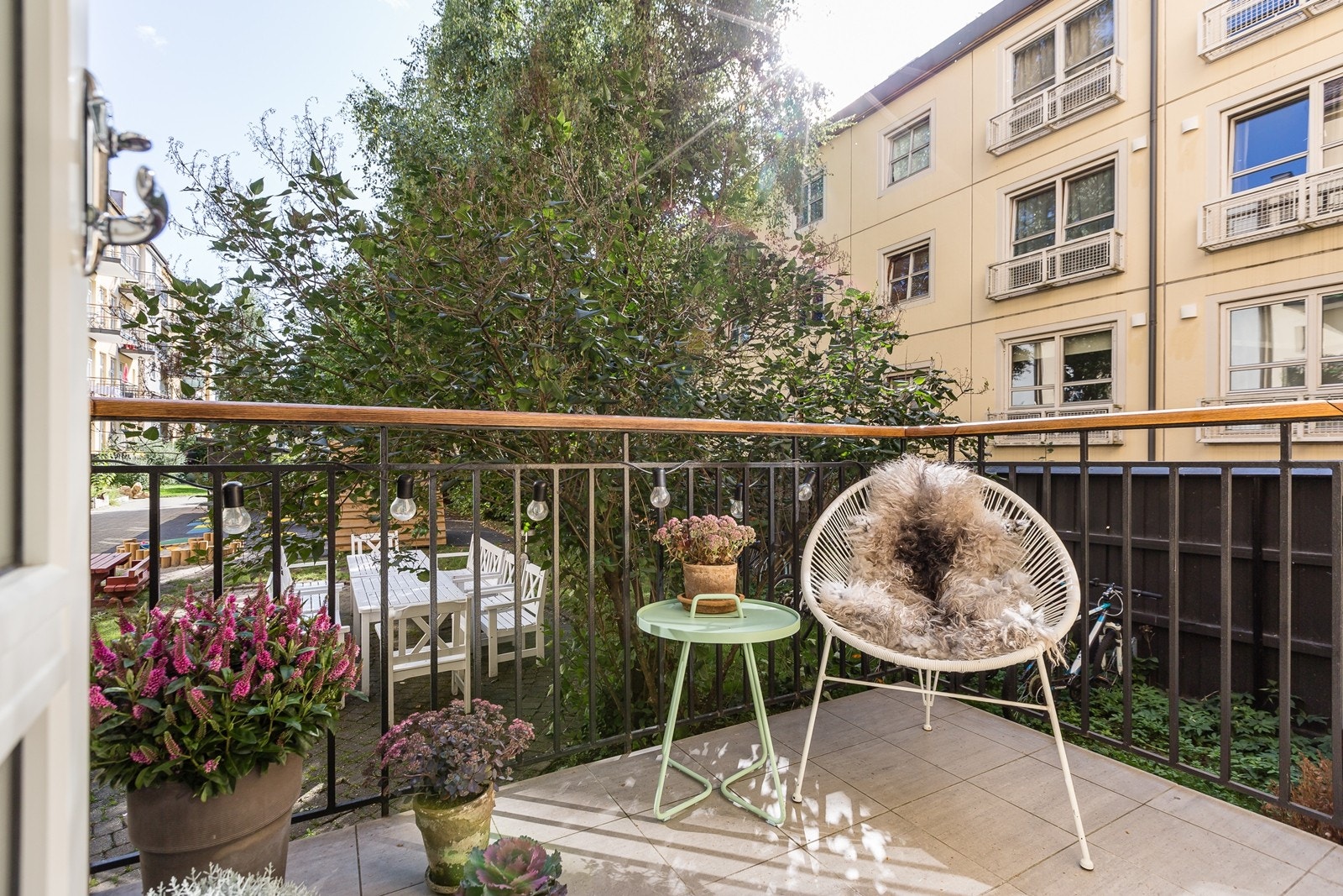 Fra balkongen er det hyggelig utsyn over borettslagets grønne og frodige bakgård Galleribilde