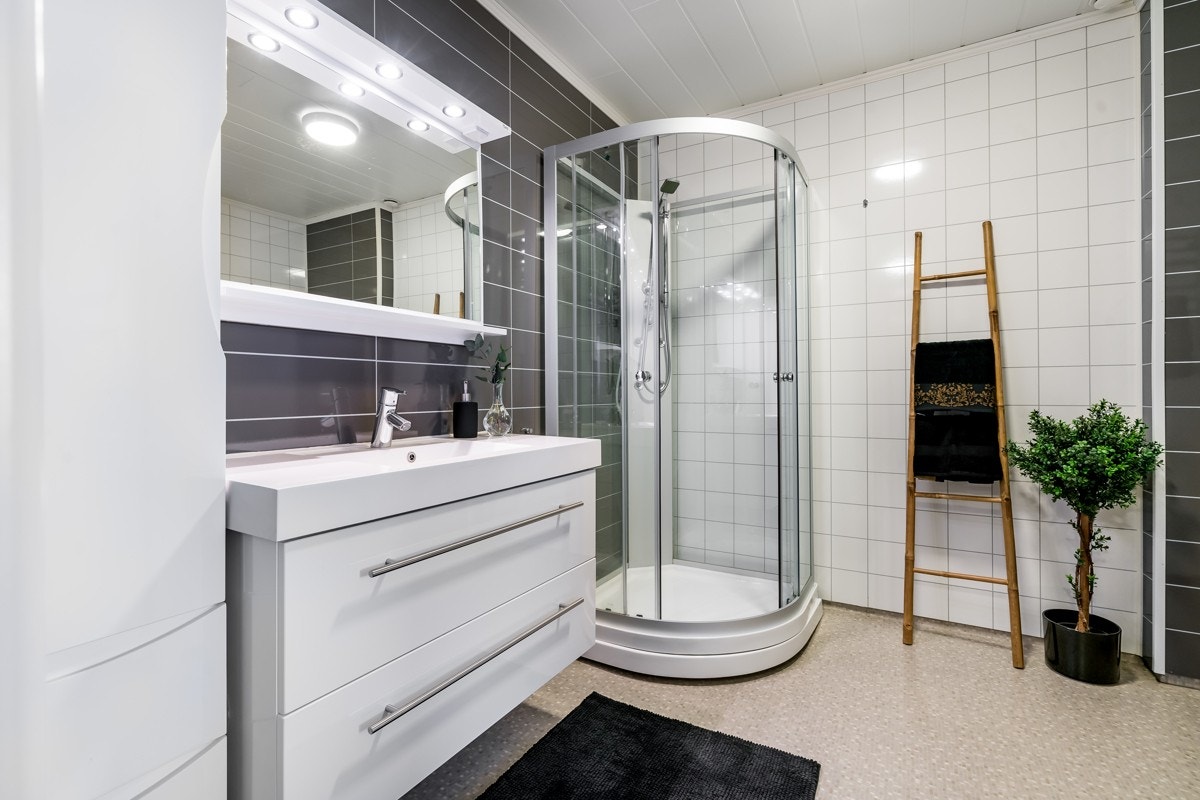 Laminatgulv er kombinert med hvite og grå våtromsplater på veggene. Galleribilde