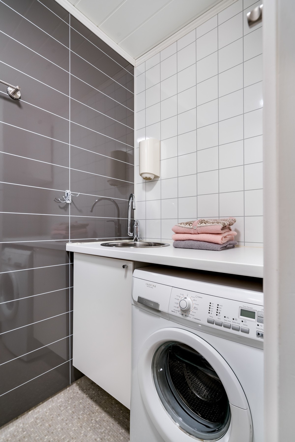 Innerst har badet en egen vaskeavdeling med benkeplate, skap og opplegg for vaskemaskin. Galleribilde