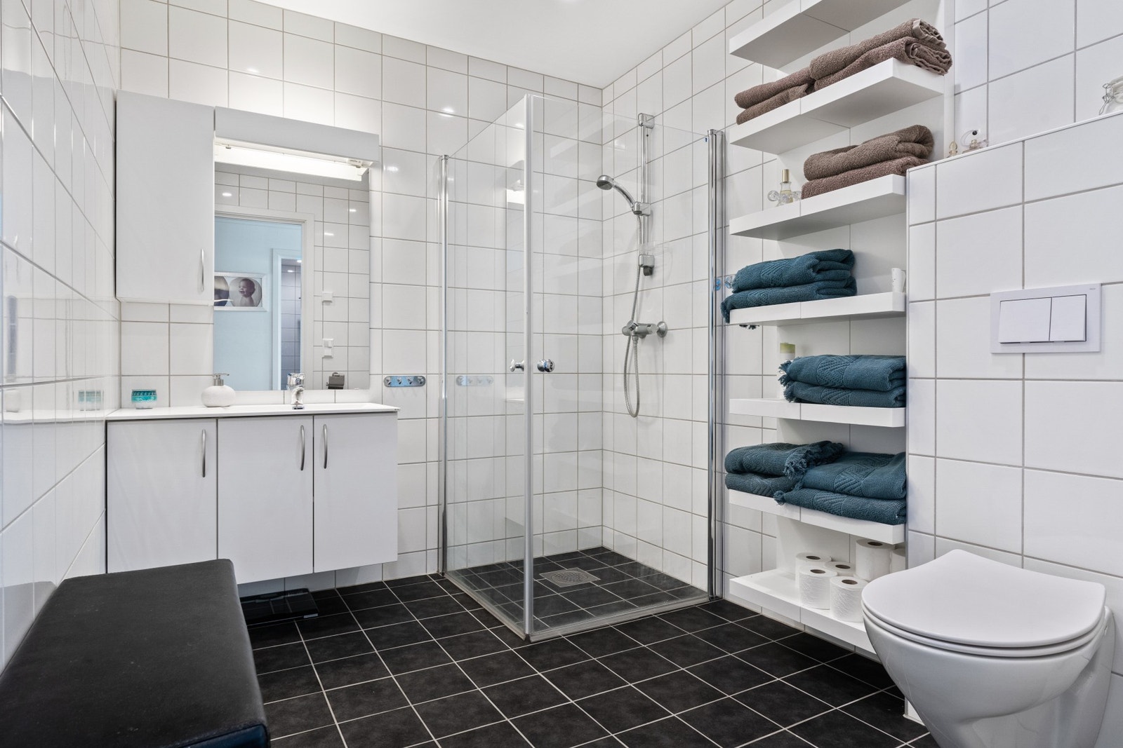 Lyst og fint bad med dusjkabinett, toalett og servant Galleribilde