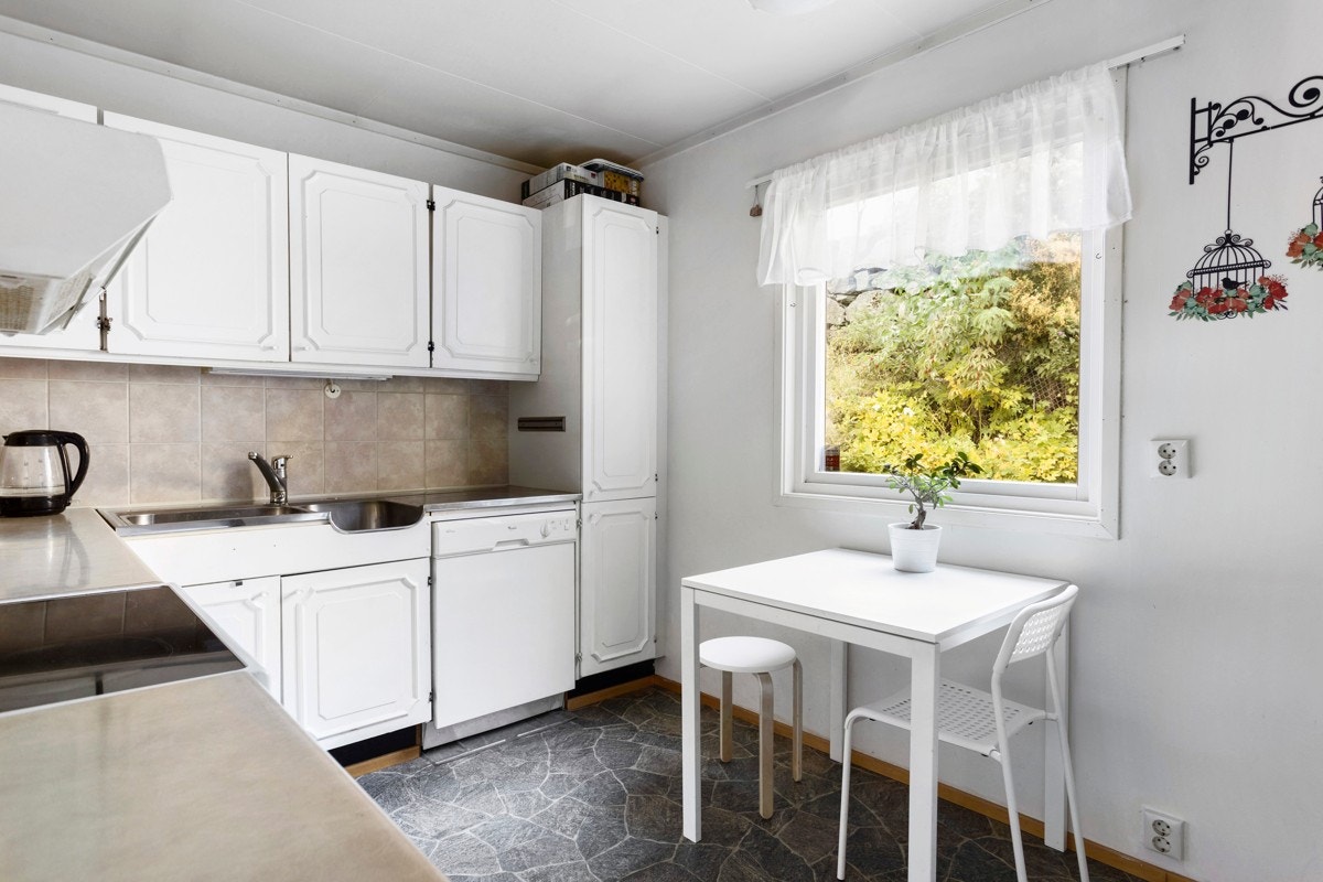 Kjøkken fra byggeår med opplegg for vaskemaskin, stekeovn, kjøleskap og rikelig med skap- og benkeplass Galleribilde