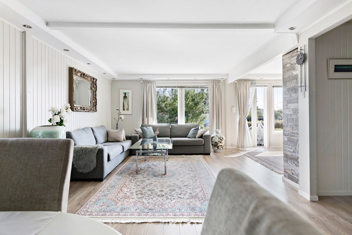 Vinklet stue med store vindusflater som slipper inn rikelig med lys Galleribilde