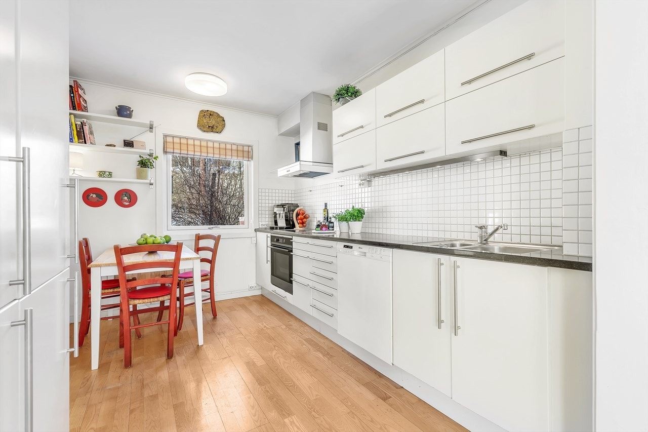 Fliser mellom benk og overskap. Kjøkkenvifte med glass og stålhette og avtrekk ut i friluft. Integrert kjøleskap, komfyr, induksjonstopp og oppvaskmaskin. Stål vaskekum nedfelt i slipt stein benkeplate. Ny komfyr og oppvaskmaskin i 2016. Galleribilde