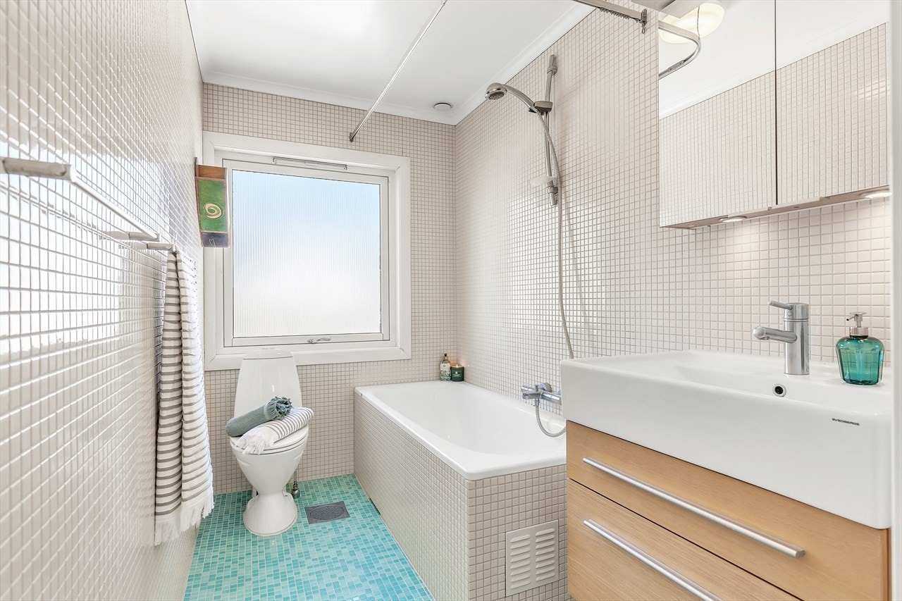 Et delikat bad/wc i 2. etasje som ble pusset opp i 2004. Badet har delikate mosaikkfliser på vegger og gulv med varmekabler. Hel servantplate med servantskap. Overskap med speildører. Toalett. Naturlig avtrekk. Innfliset badekar. Galleribilde