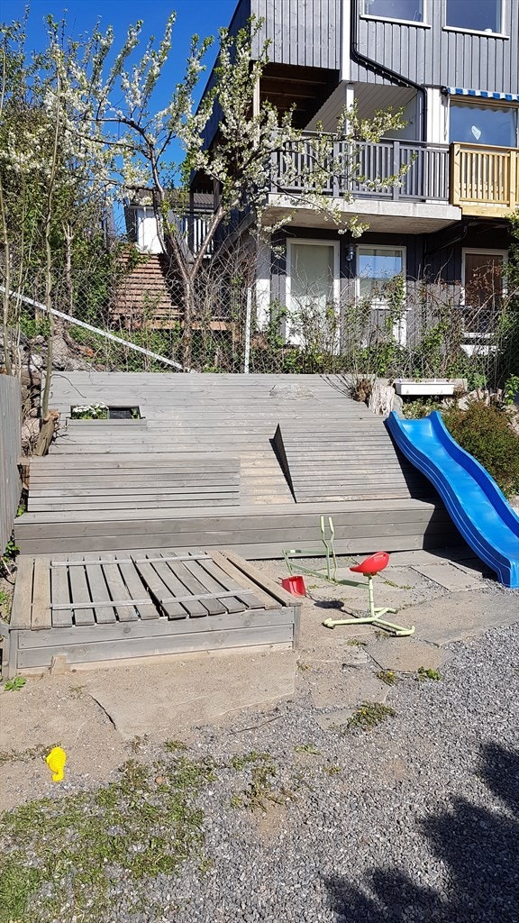 Lekeplass for de minste på sameietes tomt med sandkasse og sklie. Galleribilde