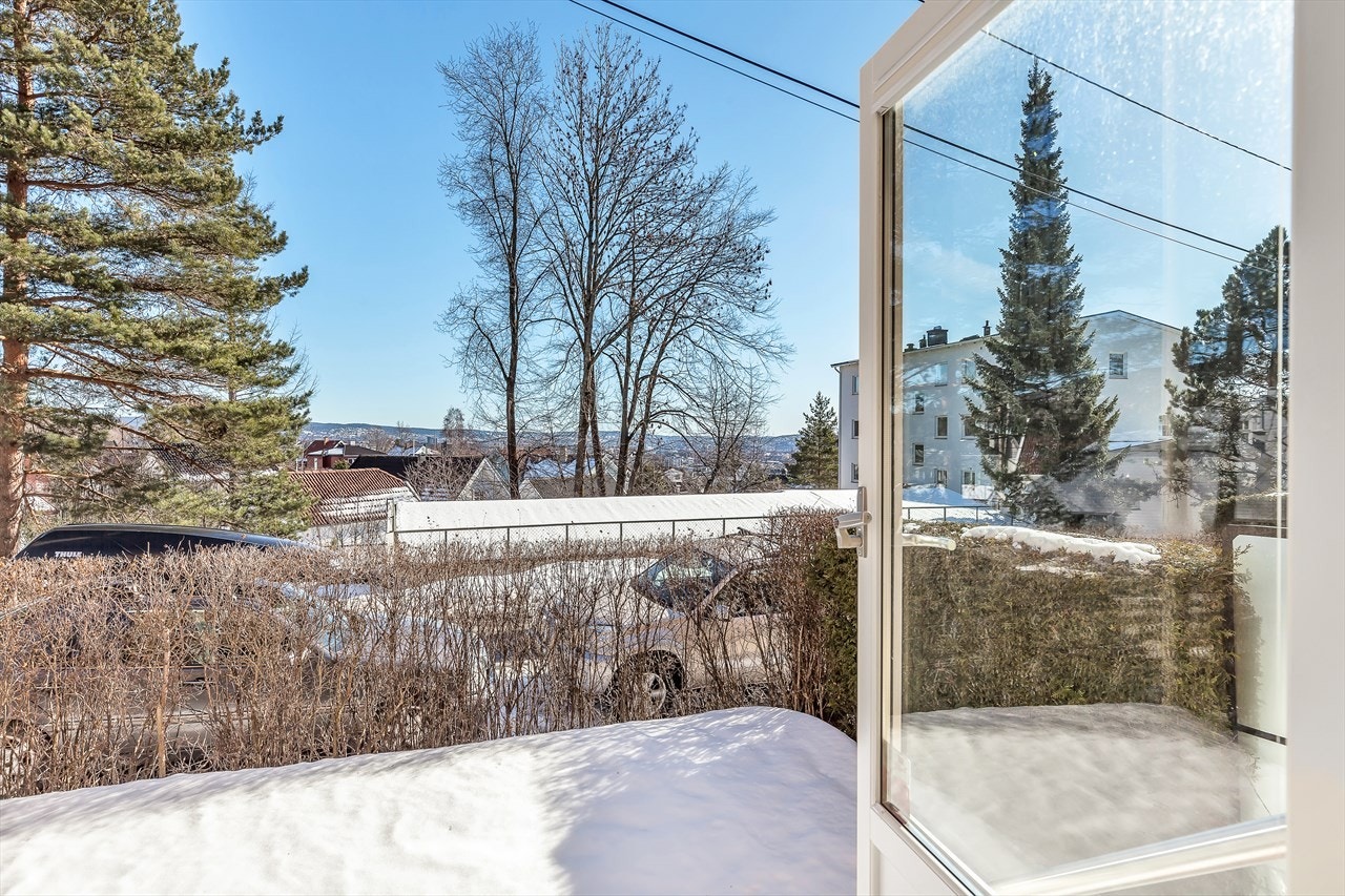 Utgang fra stuen til en usjenert og privat hage. Plen, hekk, skiferheller og bed. Her kan de små trygt stabbe inn og ut av huset uten fare for trafikk. Galleribilde