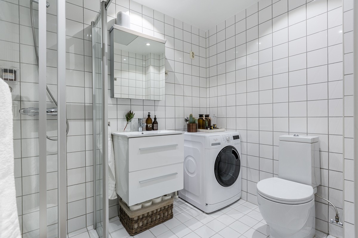 Badet består av servant med underskap, speilskap, toalett og dusjhjørne. Opplegg for vaskemaskin og tørketrommel Galleribilde