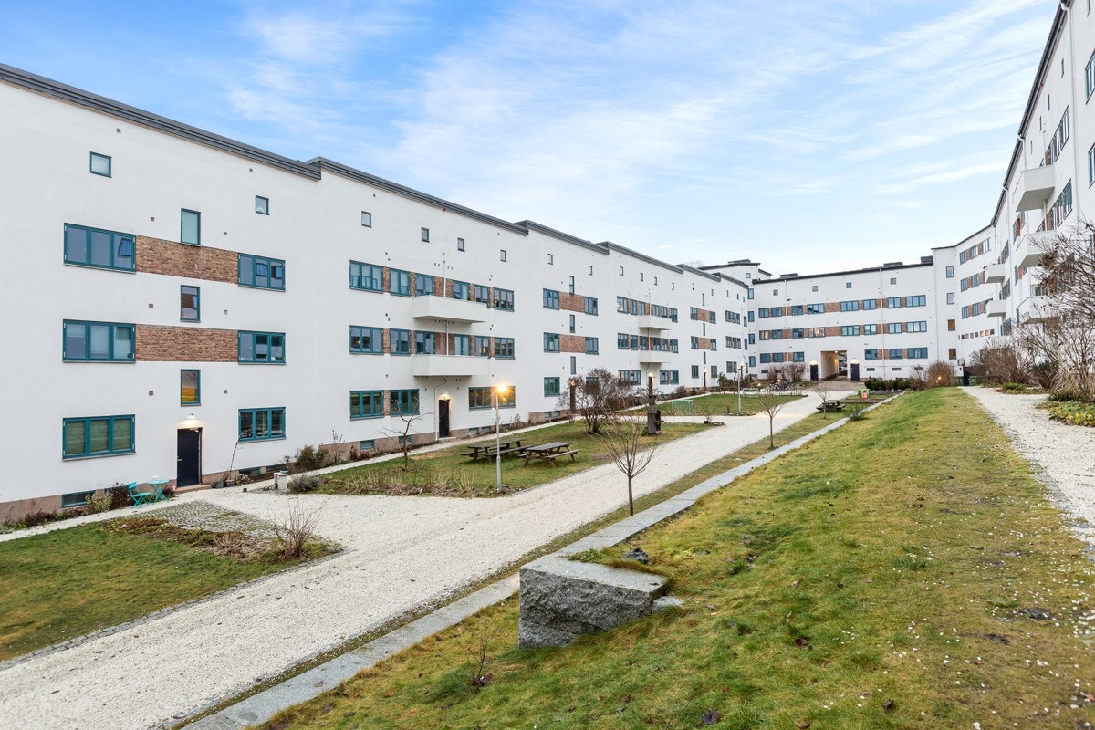 Flott opparbeidet bakgård med plenareal, beplantning og lekeplass Galleribilde