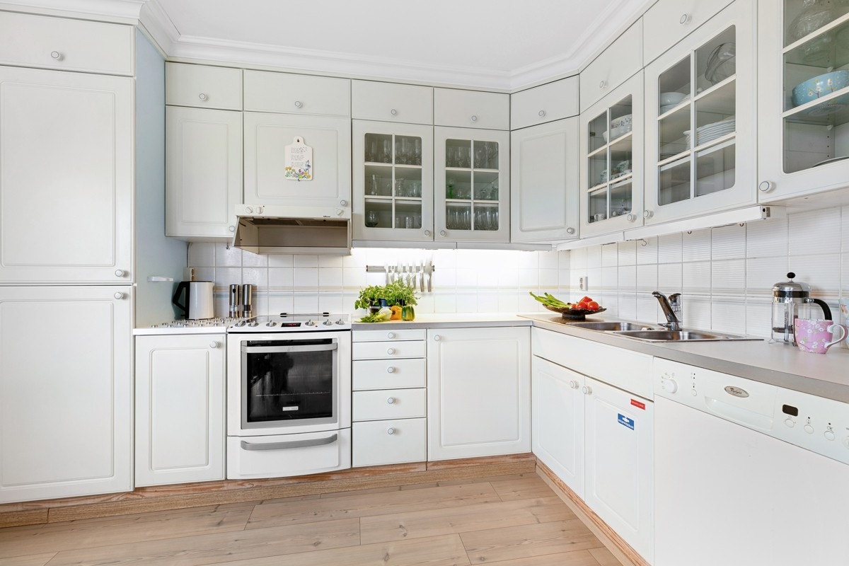 Pent kjøkken med profilerte fronter, benkeplater i laminat og nedfelt kum av stål. Galleribilde