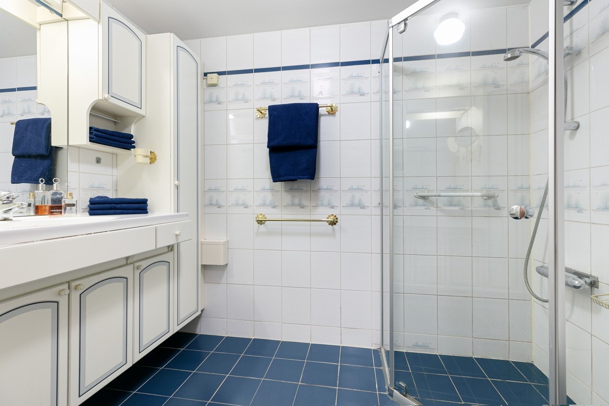 Bad innredet med toalett, dusj og servant. Galleribilde