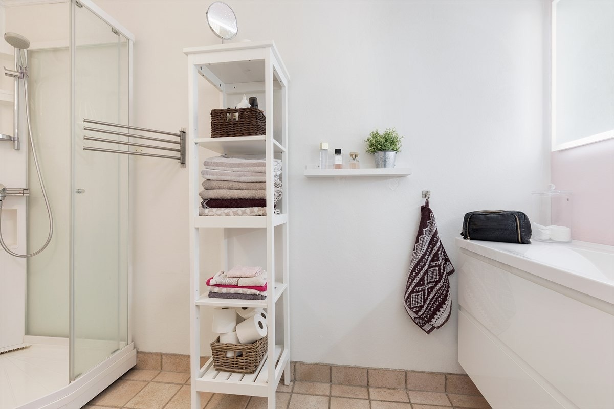 Bad med flislagt gulv, nyere dusjkabinett, toalett og nyere servant Galleribilde