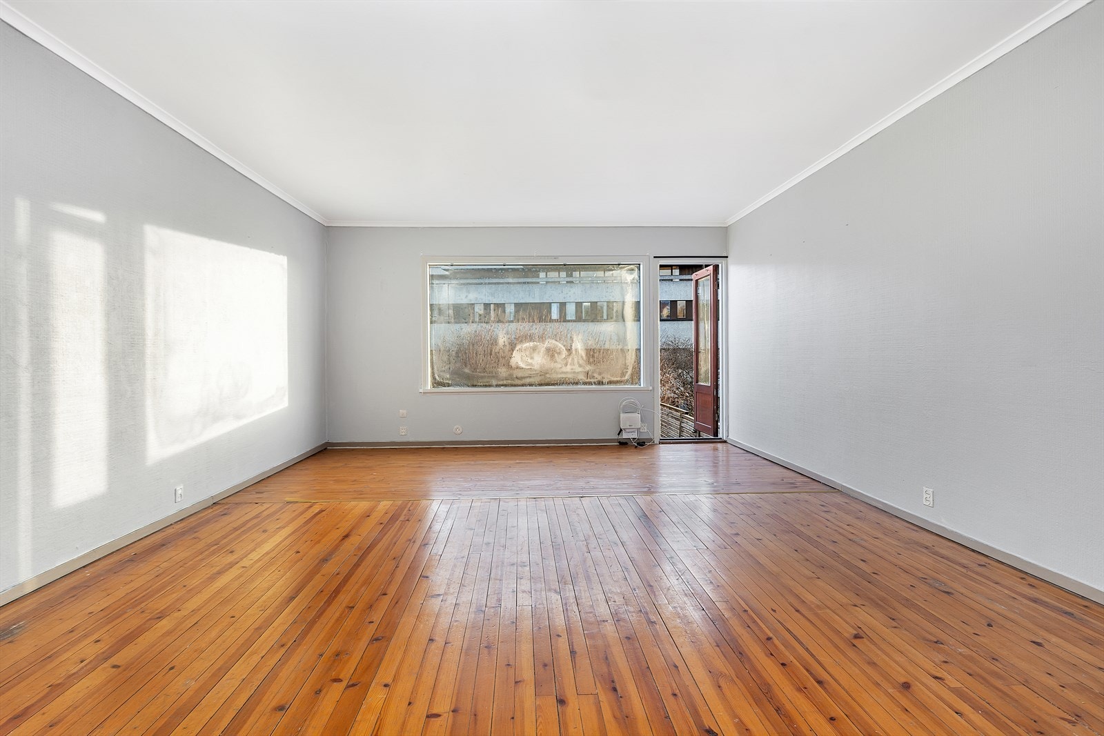 Stuen er meget romslig med vedovn og utgang til terrasse Galleribilde