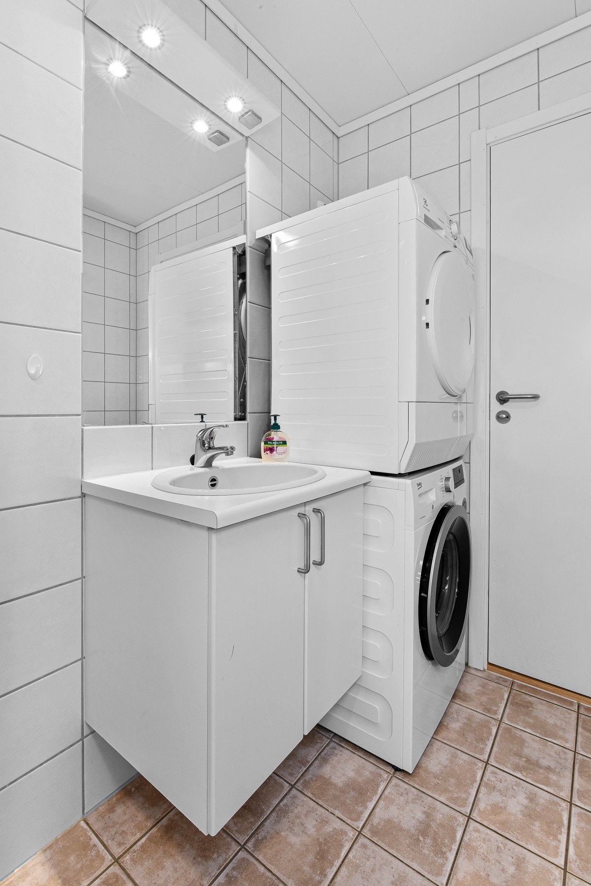Badet er pent flislagt med opplegg for vaskemaskin. Galleribilde