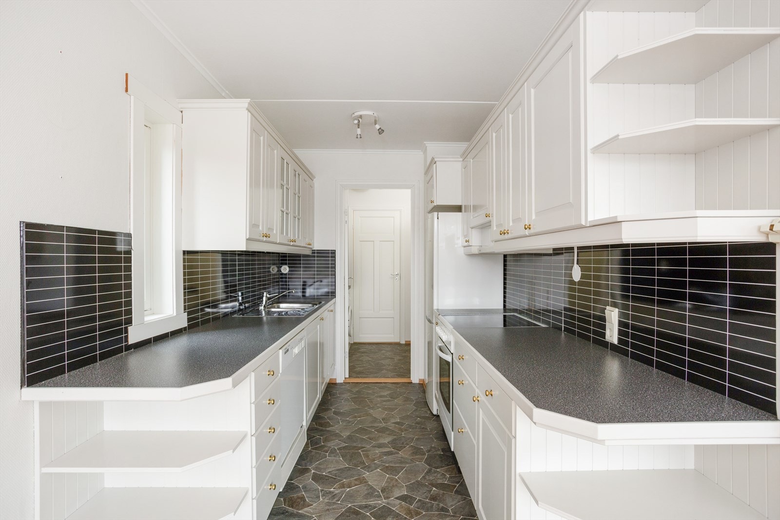 Boligens kjøkken har en Ikea innredning med hvite profilerte fronter og laminat benkeplater. Galleribilde