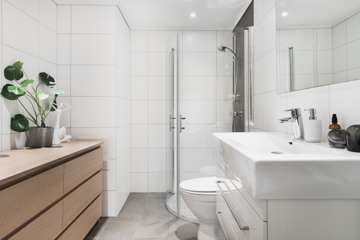 Badet er helfliset i tidløse nyanser med innfelte downlights og varmekabler i gulv. Galleribilde