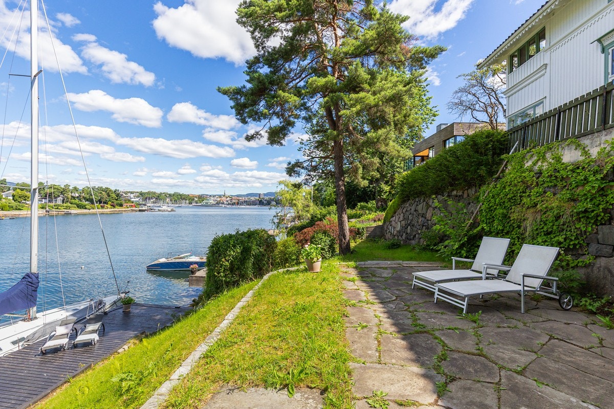 Hele eiendommen fremstår som en privat oase hvor man like enkelt kan flytte seg etter solen som å finne en sval plass i skyggen. Her legges alt til rette for ulike type sittegrupper, solsenger, grilling og sosiale sammenkomster. Galleribilde