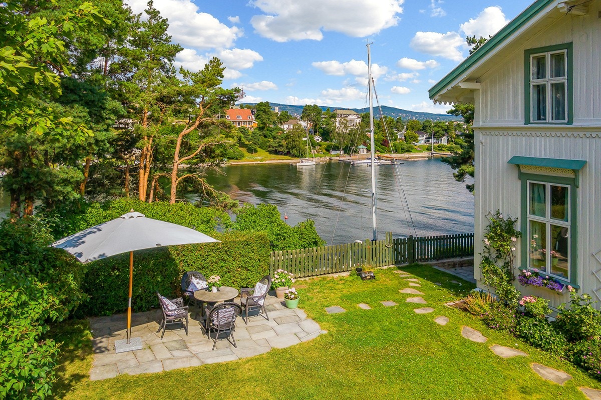 Tomten byr på et vakkert fargespill mellom velstelte prydbusker og en flora av gjennomtenkt beplantning. På siden av huset er det skiferlagt gangsti, åpent plenareal og en skiferlagt uteplass. Galleribilde