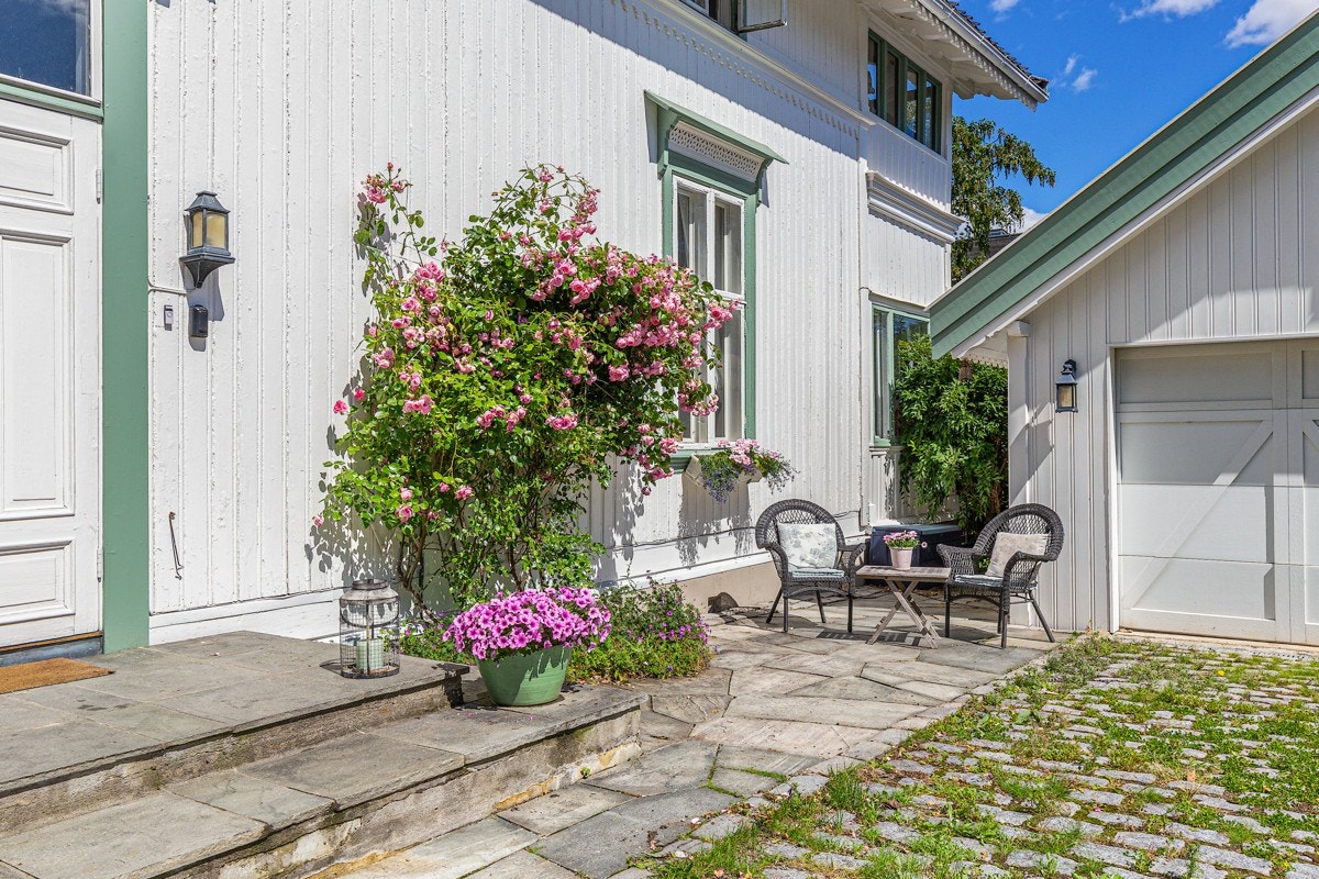 Fra gårdsplassen går det skiferbelagt trapp med varme til inngangsparti med belysning. Galleribilde