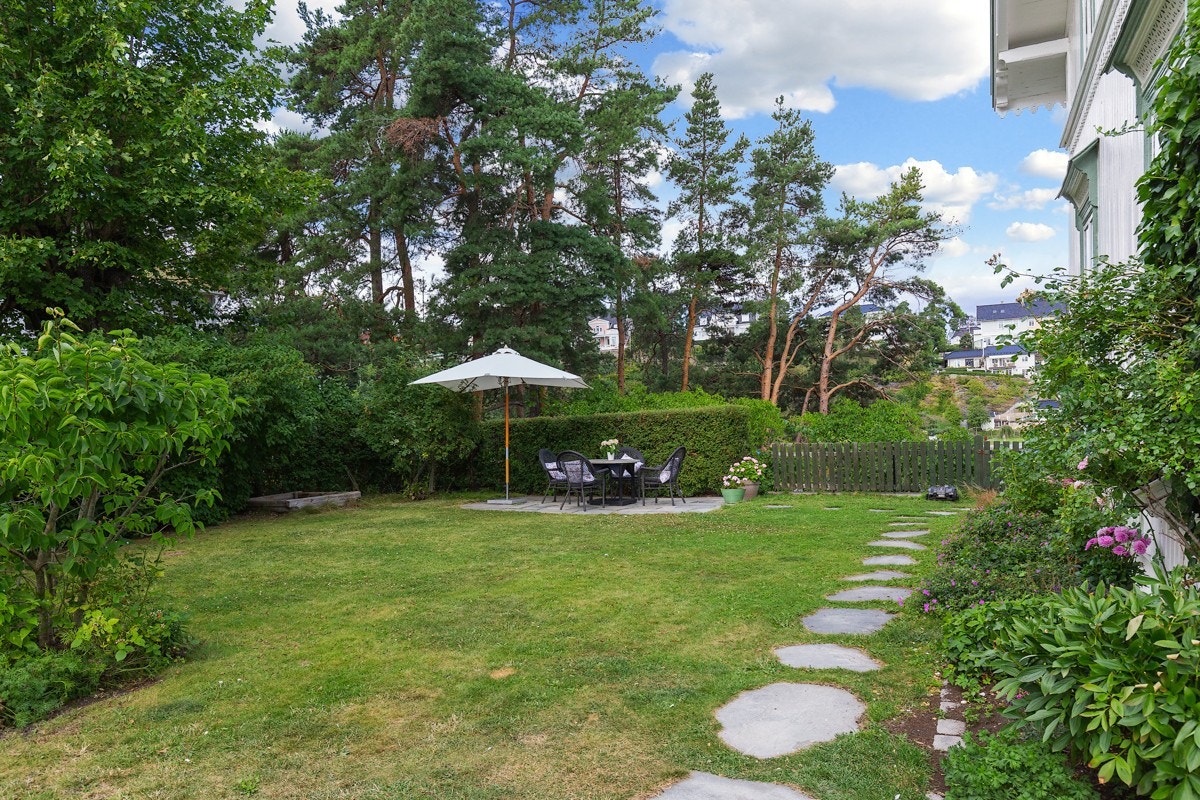 På siden av huset er det skiferlagt gangsti, åpent plenareal og en skiferlagt uteplass. Galleribilde
