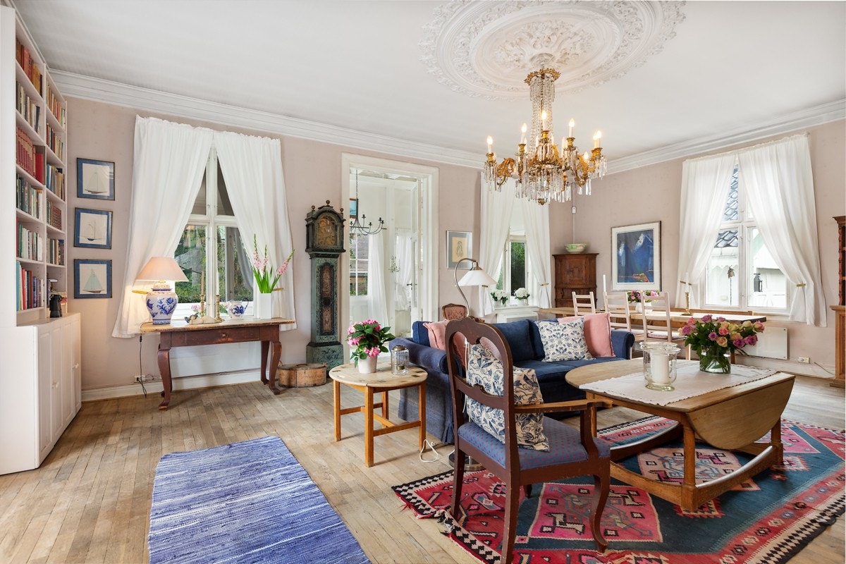 Villaen har en lys og luftig stue med herskapelig preg. Det er bred belistning, stilfull rosett i himling med elegant lysekrone fra slottet (kjøpt på auksjon i 1911). Galleribilde