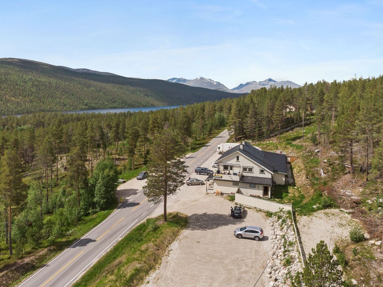Romslig med parkeringsplasser på eiendommen. Inngangspartiet til leiligheten er avskjermet med gjerde. Galleribilde