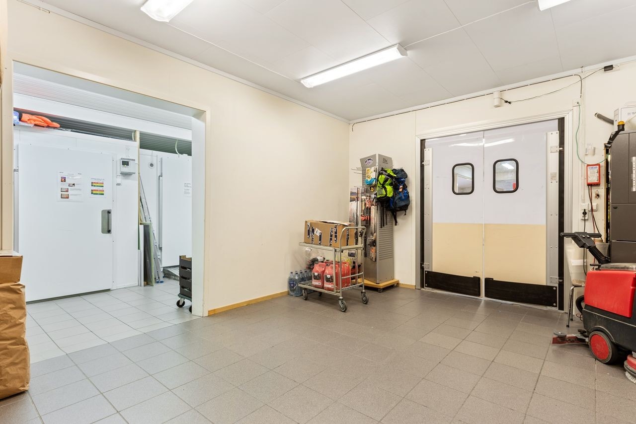 Praktisk bakrom til butikken med lager, varemottak, direkte tilgang til to kjølerom og fryserrom og varepaller kan trilles rett fra bil og inn i butikklokalet. Varmekabler i gulv. Galleribilde
