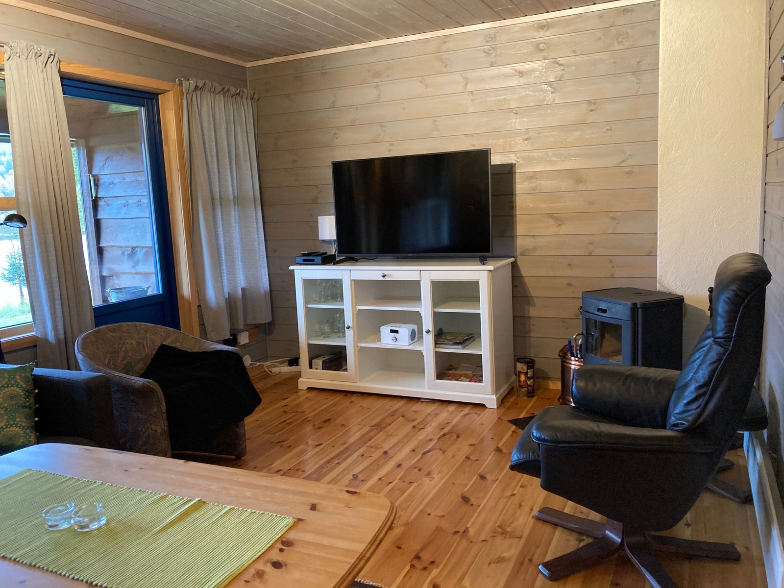 Stue med TV, skjenk og vedovn. Galleribilde