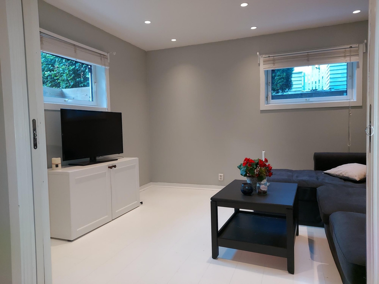 Stuen er delt i to med en skyvedør, og en del kan benyttes som soverom. Malte vegger og gulv. Galleribilde