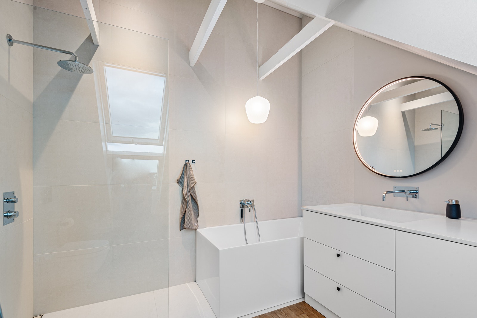 Hovedbad med badekar, dusj og mye lys fra store takvindu Galleribilde