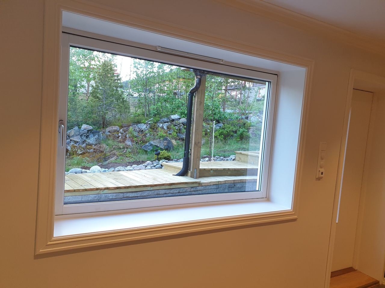 Stort vindu i stue som slipper mye lys inn Galleribilde