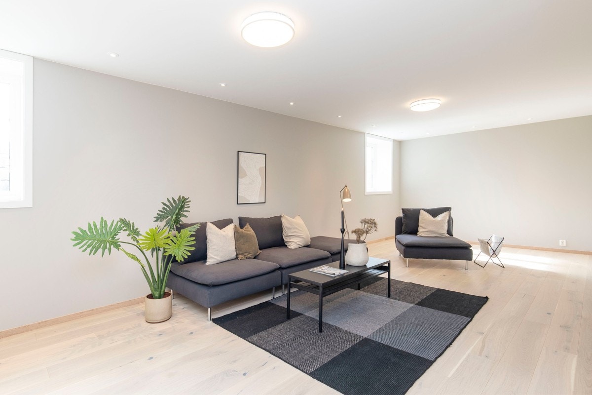 Lys og romslig kjellerstue med god takhøyde og store vinduer Galleribilde