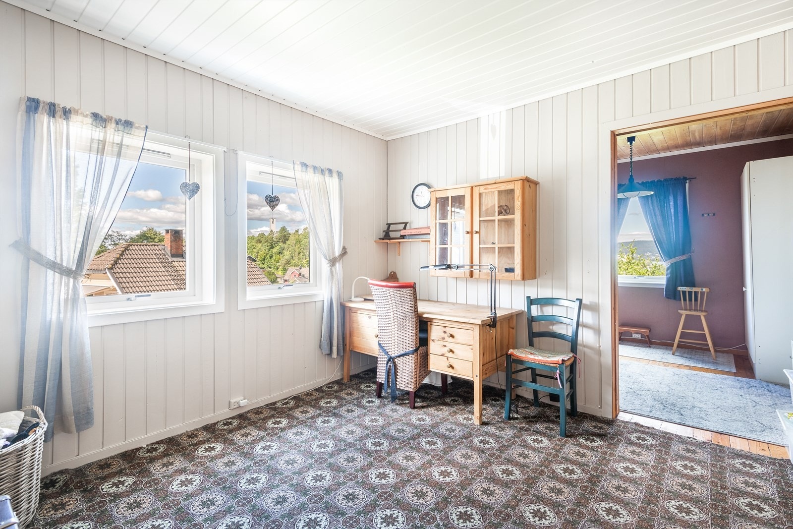 Her er det vegg til vegg teppe på gulv, malt panel på vegger samt malt puss og teglstein på brannmur og malt panel i tak. Galleribilde