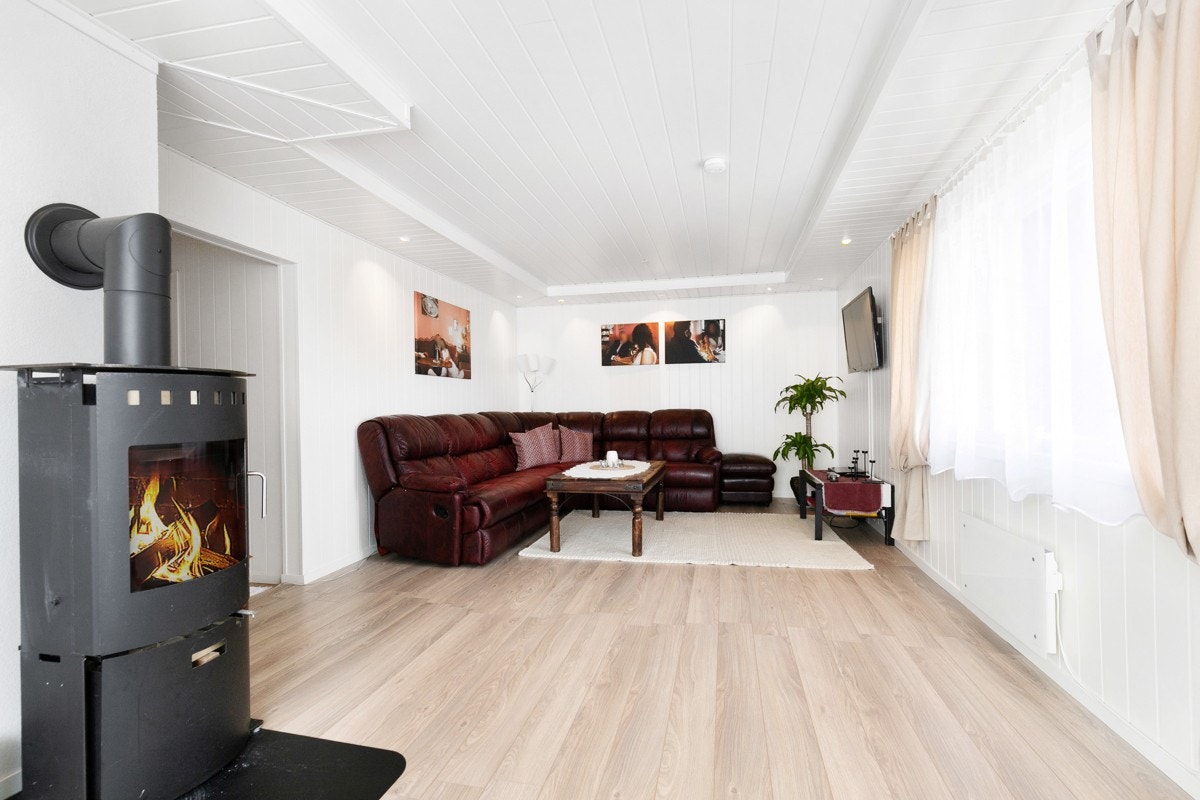 Stuen har delvis åpen løsning til kjøkkenet, og rommet har overflater av nyere dato. Det er lyse panelplater på veggene og pent laminatgulv. Galleribilde